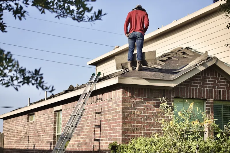 Professional roofer working on a residential roof in Jewett City